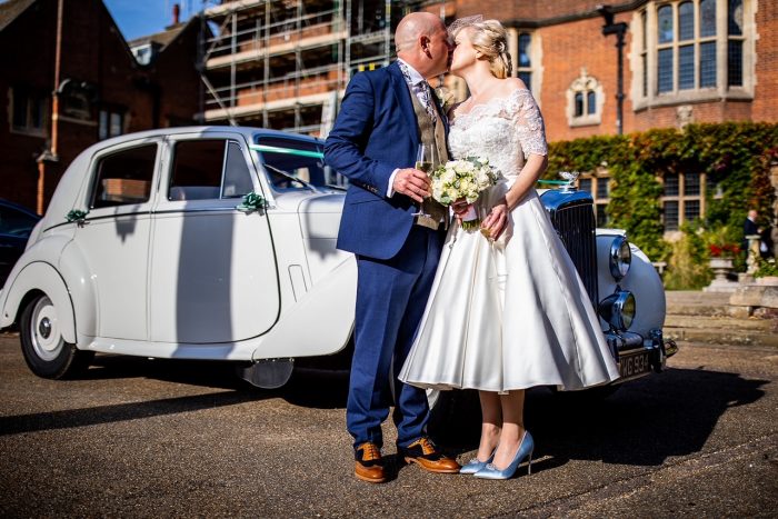 retro wedding day - couple in front of their Bentley car